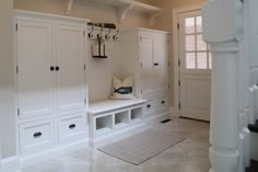 a room with white cupboards and shelves in the center, along with an entry way leading to another room