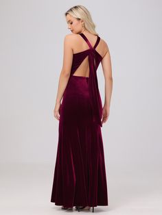 the back of a woman wearing a long velvet dress with one shoulder cut out and open sides