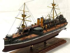 a model ship is shown on a wooden base