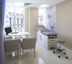 a hospital room with chairs, desks and an exam table