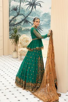 Beautiful traditional bottle green designer bridal dress for wedding occasion, beautifully decorated with gold embroidery, motifs and sequins. This traditional lehnga comes in latest design that make your look more trendy and perfect for any wedding event. Top: This designer bridal dress complemented by short frock style in traditional bottle green color is embellished with fully gold embroidery, crystals and motifs work. Neckline is highlighted with embroidery patch and with full length motif d Green Unstitched Choli With Dabka, Green Dabka Dresses For Reception, Green Dresses With Dabka For Reception, Green Dabka Salwar Kameez For Reception, Green Bollywood Choli With Dabka Detailing, Green Bollywood Choli With Dabka, Green Bollywood Choli With Dabka Embroidery, Green Dabka Choli For Diwali, Eid Green Sharara With Intricate Embroidery