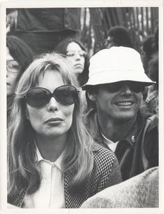 a black and white photo of people wearing sun glasses, one woman with sunglasses on her head