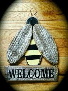 a wooden sign that says welcome with a bee on it's back and the words,