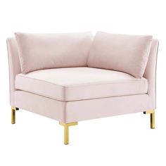 a pink chair with gold legs and pillows