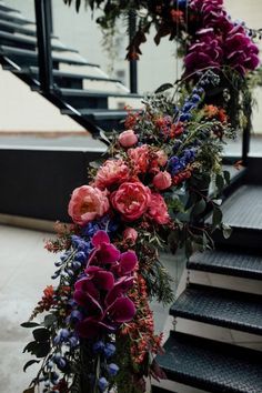 flowers and greenery are arranged on the stairs