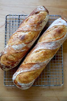 two loaves of bread sitting on top of a cooling rack