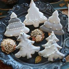 decorated christmas cookies on a plate in the shape of trees