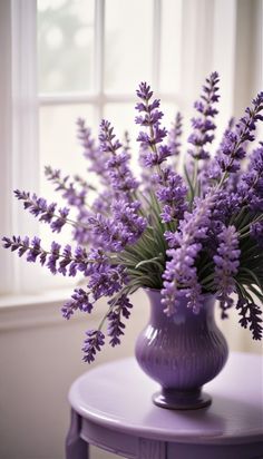 a purple vase filled with lavender flowers on top of a table next to a window