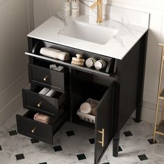 a bathroom vanity with drawers and a sink in the center, next to a gold faucet