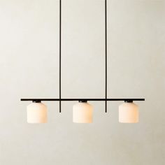 three lights are hanging from the ceiling in a room with white walls and flooring