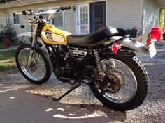 a yellow and black motorcycle parked in front of a house