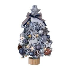 a silver christmas tree with ornaments on it and a bow around the top, is shown in front of a white background