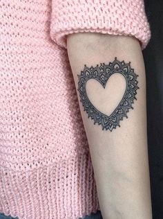 a woman with a heart tattoo on her arm