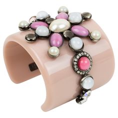 Emilio Pucci designed this adorable massive resin baroque bracelet bangle. The chunky cuff is made of pale pink resin ornate with a gunmetal framing geometric design topped with poured glass cabochons and crystal rhinestones. The jewel design has assorted colors of pearly, arctic white, antique pink, and pearlized watermelon pink. Emilio Pucci's hallmark is engraved on the inside of a metal tag. This piece will come with its original branded dust bag. Measurements: inside across in 2.32 in wide Baroque Bracelet, Framing Design, Jewel Design, Resin Bracelet, Metal Tag, Rose Pale, Metal Tags, Bag Measurements, Textile Jewelry