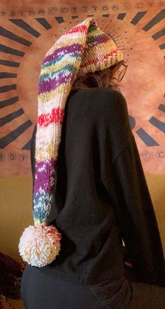 a woman wearing a multicolored knitted hat and scarf