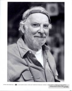 black and white photograph of a man with a beard wearing a head band, looking at the camera