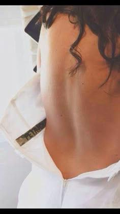 the back of a woman's white shirt and tie