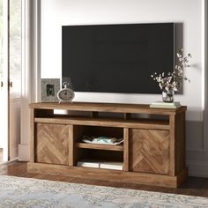 a wooden entertainment center with a blackboard in the back ground and flowers on top