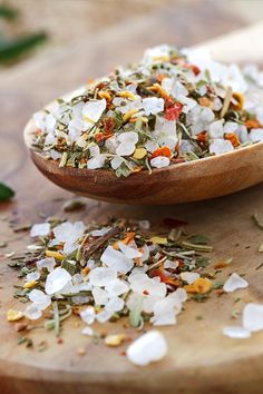 a wooden spoon filled with white and orange flowers