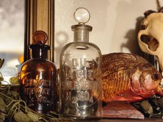 a fish in a glass bottle sitting on top of a table next to other items