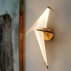 a clock that is on the wall next to a light fixture with an origami design