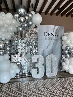 balloons and decorations are displayed in front of a sign that reads,'30 '