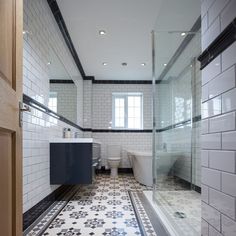 a bathroom with white and black tiles on the floor