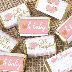 pink and gold baby shower candy bar wrappers with pumpkins on them sitting on a table