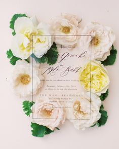 a wedding card with white flowers and greenery