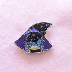 a purple and black pin with an image of a bird on it's back