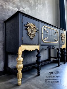 an ornate black and gold sideboard on display in a room with grey walls, wooden floors and flooring