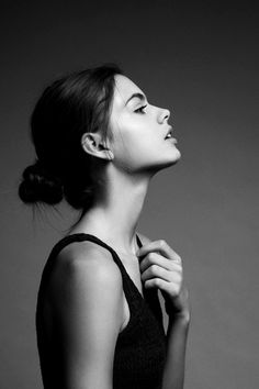 a black and white photo of a woman with her head tilted to the side looking up