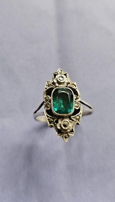 A gorgeous original Art Deco ring. Hallmarked sterling silver. A paste stone with the look of a beautiful emerald.  Studded with twinkling marcasites, with a tiny forget me not flower detail to the top & bottom. Ring size N, US size 7. The front of the ring is just over 2cm tall. Such an elegant shape ~ Vintage Green Emerald Ring With Rose Cut Diamonds, Art Deco Emerald Ring With Rose Cut Diamonds, Art Deco Green Emerald Ring With Rose Cut Diamonds, Antique Green Emerald Cut Ring, Antique Green Emerald Cut Emerald Ring, Antique Green Emerald-cut Emerald Ring, Antique Emerald Cut Green Emerald Ring, Classic Green Jewelry With Rose Cut Diamonds, Vintage White Gold Emerald Jewelry