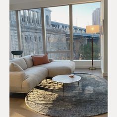 a living room with large windows and a couch in front of the floor to ceiling window