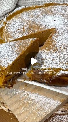 there is a cake that has been cut and served on a cutting board with powdered sugar