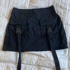 Super Cute Black Mini Cargo Skirt With A Stretchy Back Deep Pocket And Cool Buckle Design. Used Ones But Basically Like Brand New 14” Or So Waist When Relaxed But Has Stretchy Back And Can Stretch Up To 16” Or So High Waist Black Cargo Skirt With Belt Loops, Black High-waist Cargo Skirt With Belt Loops, High-waist Black Cargo Skirt With Belt Loops, High Waist Black Mini Skirt With Pockets, Y2k Style Black Skirt With Pockets, Casual Black Skirt With Belt Loops, Y2k Black Skort With Pockets, Black Y2k Skort With Pockets, Fitted Black Mini Cargo Skirt