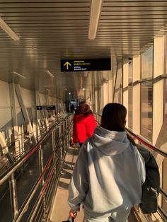 two people walking down an escalator with luggage