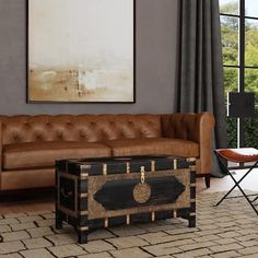 a living room with a brown leather couch and coffee table in front of a large window