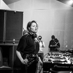 a woman standing in front of a dj set