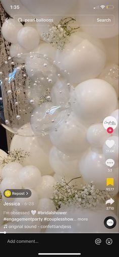 balloons are floating in the air with white flowers and greenery on them, as well as bubbles