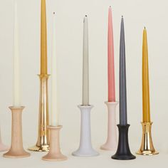 five candles are lined up in different colors and sizes, with one candle sticking out from the top