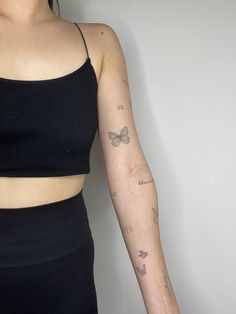 a woman with a butterfly tattoo on her left arm and right arm behind her back