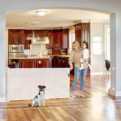 a woman and child standing in a kitchen with a dog