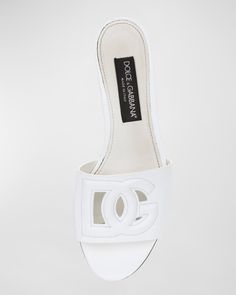 Dolceamp;Gabbana sandals in calf leather with DG cutout logo    Flat heel    Open toe    Single band vamp     Slide style     Runs small; order 1/2 size up.    Made in Italy White Open Heel Sandals In Calf Leather, White Calf Leather Mules, Luxury Leather Sandals With Logo, White Luxury Calf Leather Mules, Luxury White Calf Leather Mules, Designer Leather Sandals With Logo, Logo Open Toe Sandals For Summer, Designer Low Heel Summer Mules, Open Toe Sandals With Logo For Spring