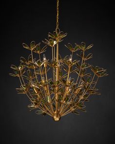 a gold chandelier with green leaves hanging from it's center and bottom