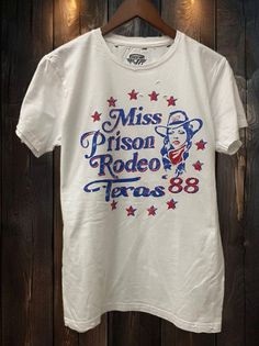 Country Deep Miss Prison Rodeo Texas 1988 vintage unisex distressed T shirt in vintage wash white Throw back vintage tee from the Bakersfield prison rodeo 1988 40 Singles Jersey 100% Cotton Premium quality ringspun and compacted cotton Fine Cotton Jersey that is pigment dyed for a more vintage look Features tears and destroyed features at neck and on body Each piece is unique as this process is done by hand! 3.8 oz Made In USA Every garment dye item can be a slightly different shade in color sin White Crew Neck T-shirt For Rodeo, White Short Sleeve T-shirt For Rodeo, White Screen Print T-shirt For Rodeo, Vintage Letter Print Tops For Rodeo, Retro Rodeo T-shirt With Screen Print, Vintage Relaxed Fit T-shirt For Rodeo, Retro Style Crew Neck T-shirt For Rodeo, Retro Rodeo Crew Neck T-shirt, Retro Crew Neck T-shirt For Rodeo