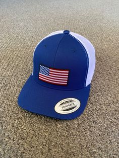 "This is a NEW United States of America Flag Embroidered Patch applied by hand to a high quality Yupoong or Richardson brand snapBack trucker hat Yupoong Classic SnapBacks are 65% Polyester/35% Cotton Structured 3 1/2\" mid-profile six-panel Permacurv Visor adjustable 6 7/8\" to 7 1/2\" Richardson Hats are 60% cotton/40% polyester Structured 3 1/2\" mid-profile six-panel Pre-curved Visor adjustable snapback closure 6 3/4\" -7 5/8\" Every Hat Design is Created and Individually HANDCRAFTED to orde Blue Cap With Embroidered Patch, One Size Fits Most Trucker Hats With Flat Brim, Trucker Hat With Curved Brim For Baseball Season, Trucker Style Baseball Cap For Baseball Season, Trucker Hat With Curved Brim, One Size Trucker Hat With Curved Brim, Country Style Adjustable Snapback Baseball Cap, Adjustable Country Style Snapback Baseball Cap, Patriotic Snapback Hat With Flat Bill For Outdoor