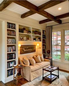 a living room filled with lots of books and furniture