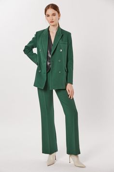 This Deluc Sophia Blazer is a stylish and sophisticated addition to your wardrobe. The double breasted blazer is crafted from a polyester-rayon blend in a bold pine green hue and features an oversized fit. The model is wearing an XS.