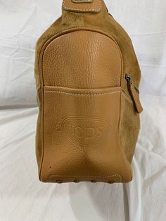 "Measurements are 14\" top wide, 9\"5 high, 5\" deep with one 13\" shoulder strap with a 5\" drop. This bag is adorned with one main compartment, back zipper pocket, lined in brown fabric and a top zipper closure. The leather is nice and strong with no tears and there is minor balding on calf hair. Bag has all working zippers, 4 exterior pockets, light stitching and bag is spacious. Made in Italy with serial# L8 07 and is 100% genuine Tod's. -----------------------------------------I SHIP WORLDW Bell Gardens, Hair Bag, Top Handle Bags, Leather Bucket, Brown Fabric, Calf Hair, New Bag, Dooney Bourke, Tan Leather